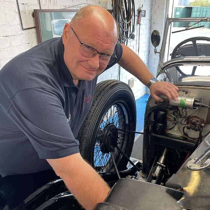 Richard Anderton fixing a vintage car